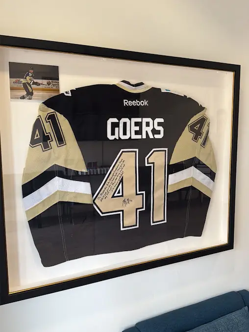 Framed signed jersey on the clinic wall